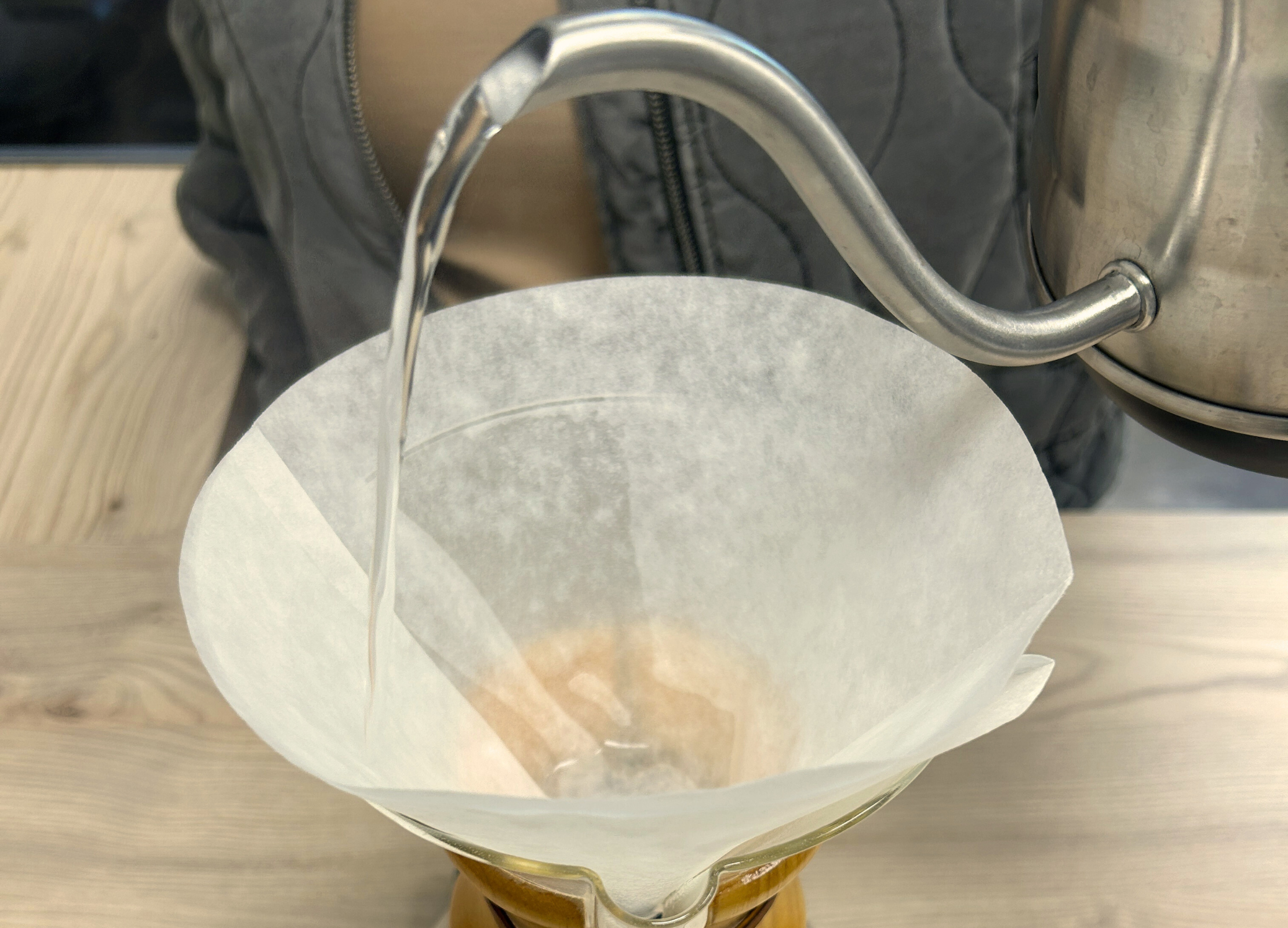 Heißes Wasser wird in einen Papierfilter in einer Chemex-Karaffe gegossen