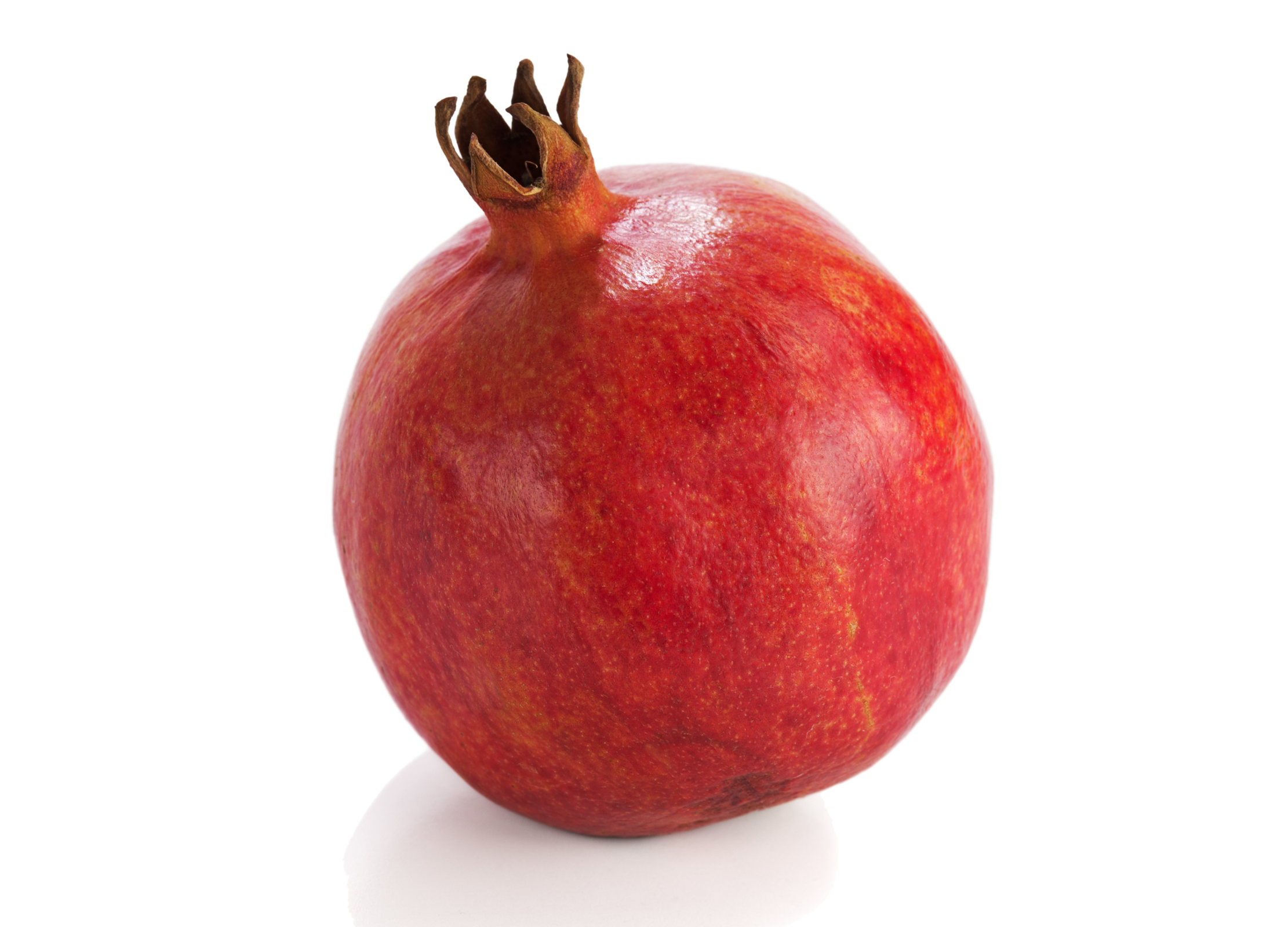 Roter Granatapfel mit glänzender Schale steht auf weißem Untergrund