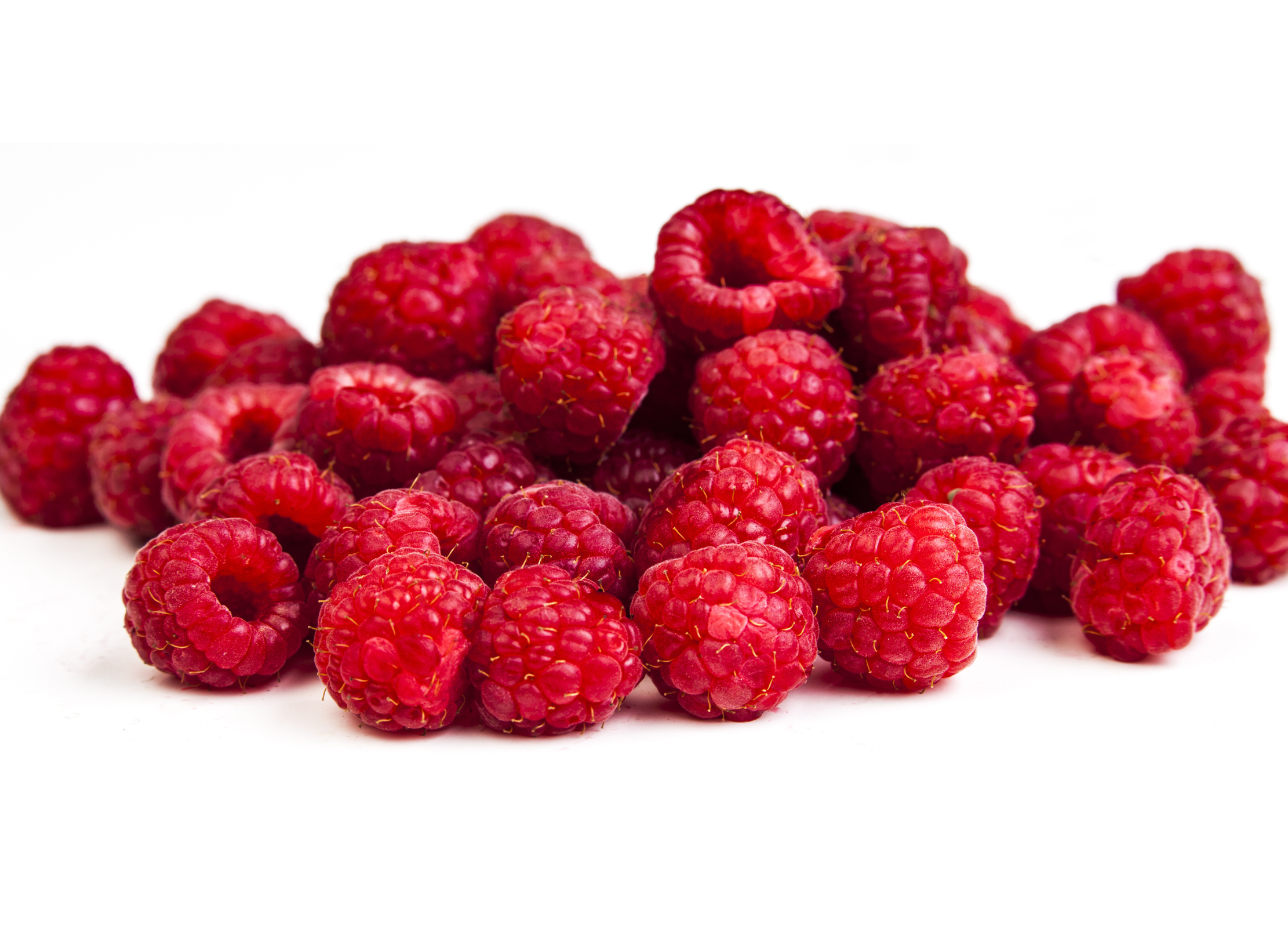 Ein Haufen frischer, leuchtend roter Himbeeren mit feiner Struktur auf weißem Hintergrund