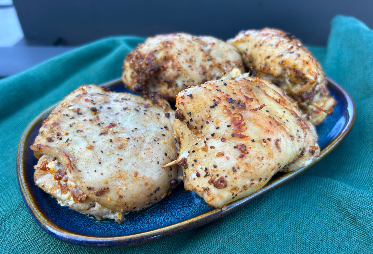 Gegrillte Hähnchenspiesse mit Gewürzbelag auf blauem Teller auf türkisem Untergrund