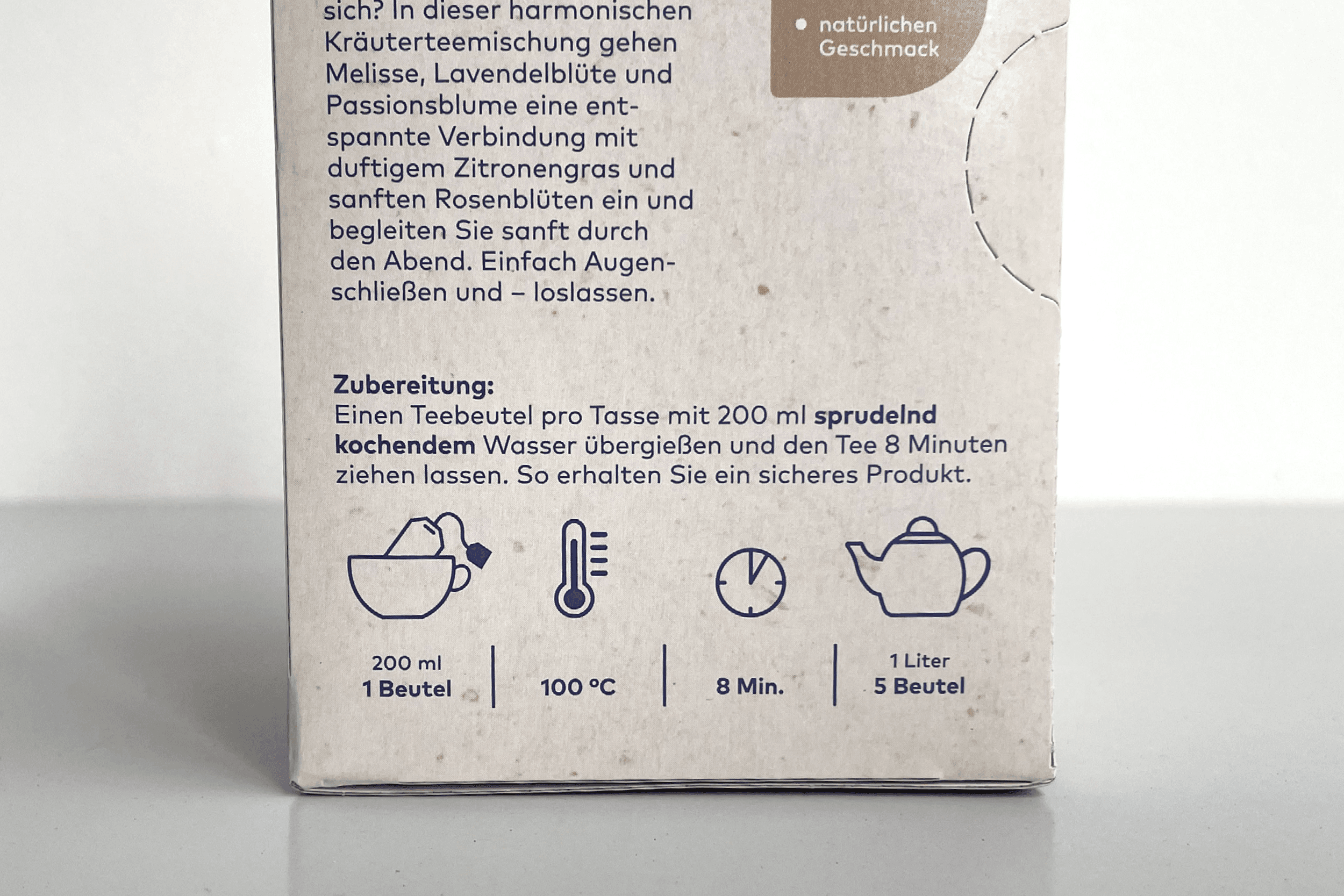 Rückseite einer Teeverpackung mit Zubereitungsanleitung für Kräuterteemischung mit Melisse, Lavendelblüte und Passionsblume. Symbole zeigen: 200 ml, 100°C, 8 Minuten Ziehzeit.