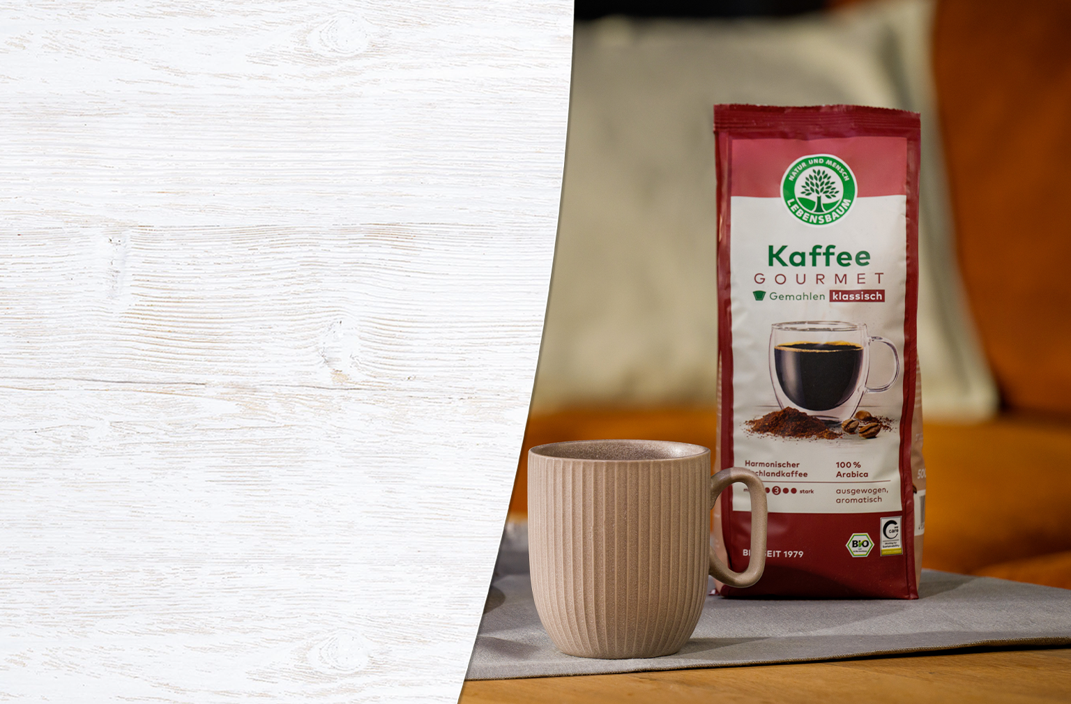 Lebensbaum Kaffee Gourmet in roter Packung neben cremefarbener Kaffeetasse auf grauem Untergrund, 100% Arabica Bio-Kaffee, klassisch gemahlen