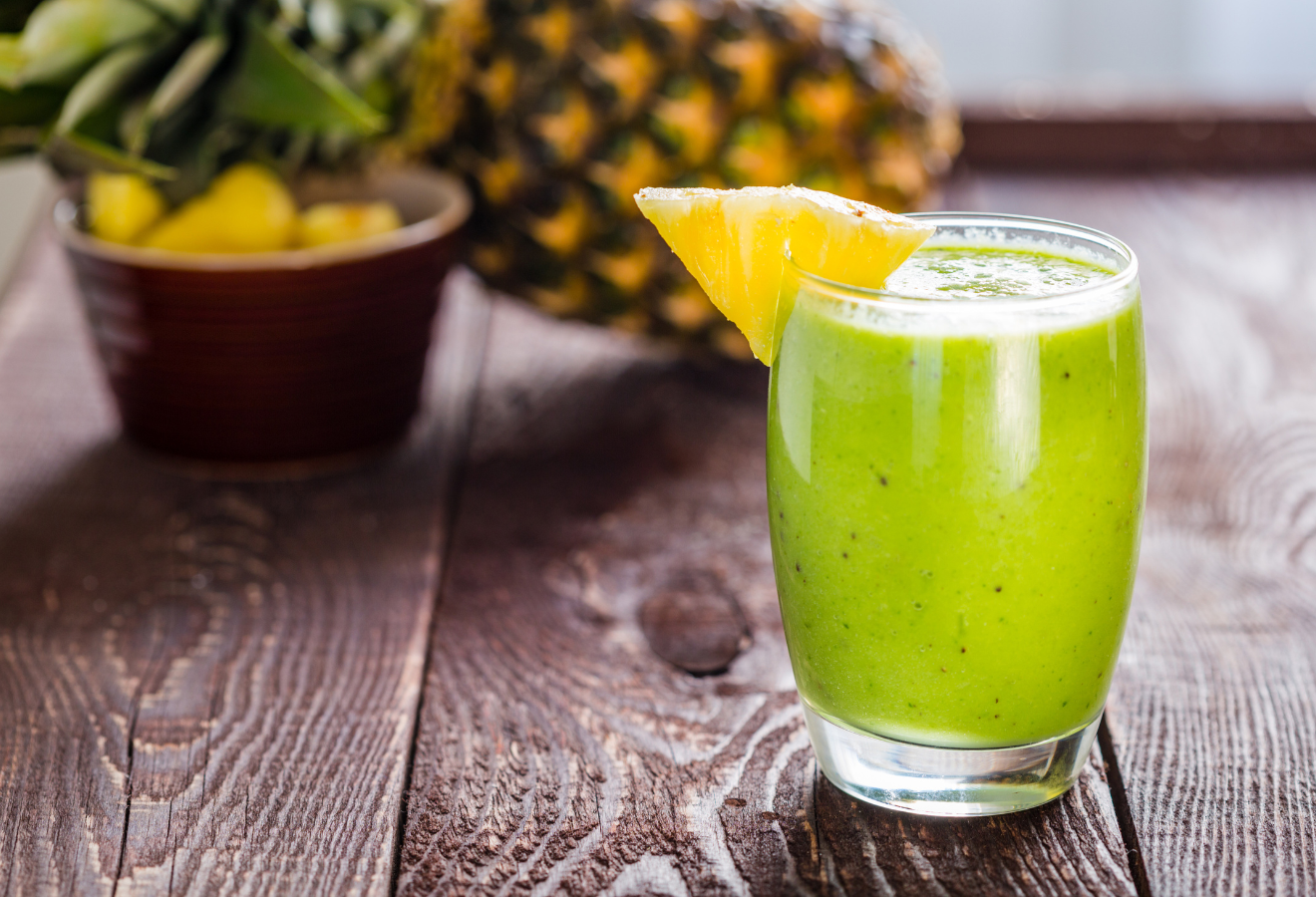Sportlicher Smoothie in einem Glas mit Ananas garniert