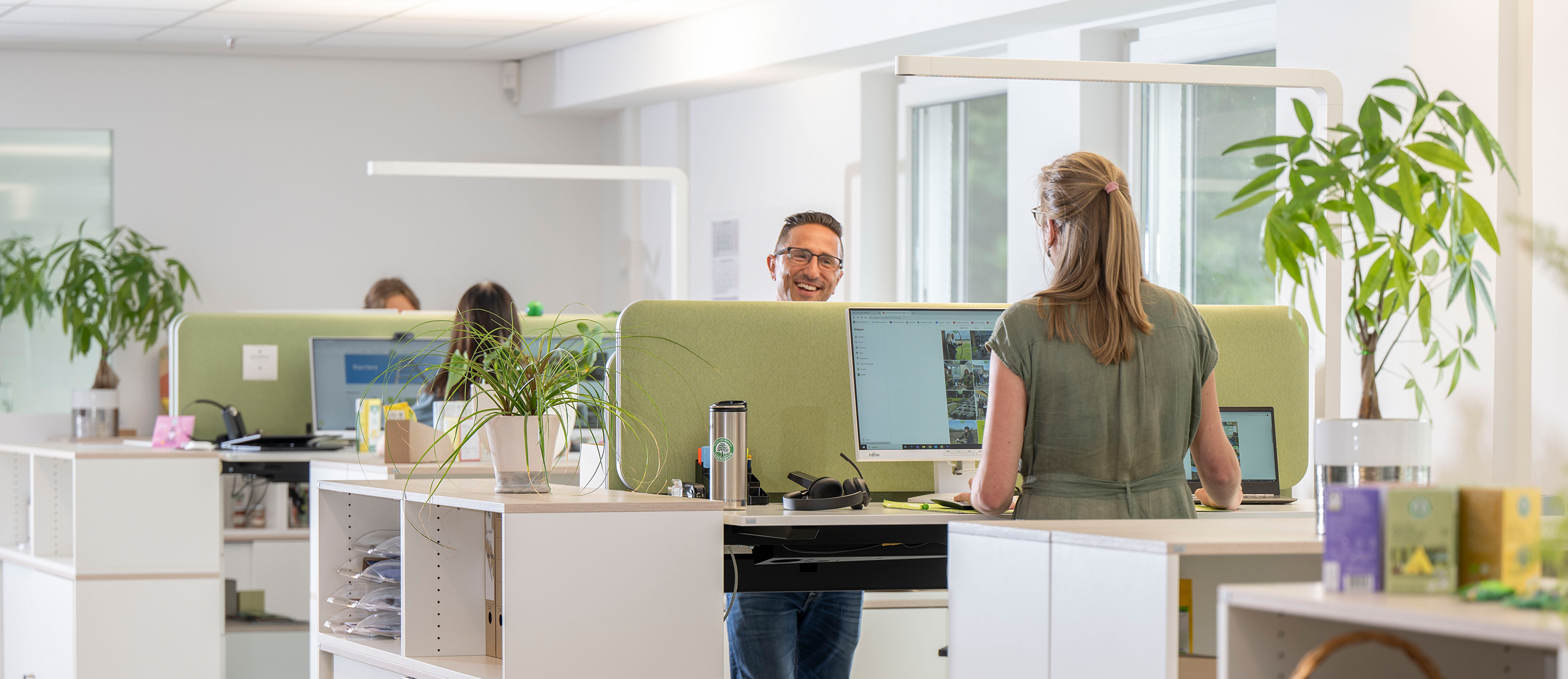 Menschen arbeiten an höhenverstellbaren Schreibtischen in unserem modernen Großraumbüro in Diepholz 